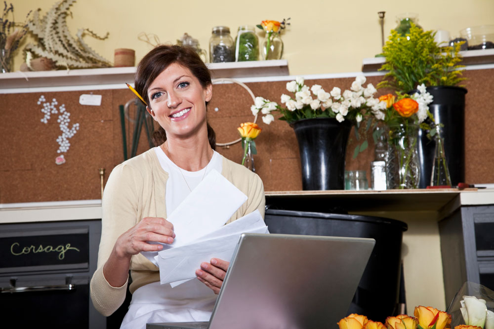 A women running her floral shop - Contact Paramount if you need help filing taxes for your business.